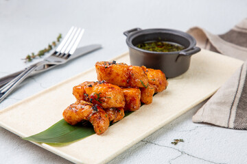 Slices of pike perch in sweet and sour sauce on a banana leaf