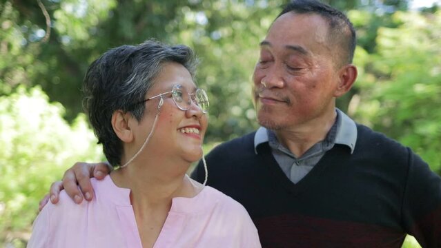Portrait of an elderly Asian couple smiling happily in the garden. Living a happy retirement life. health care