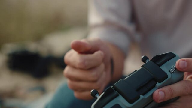 A male screws a joystick into a drone controller. close-up shot. Day, outdoor. 