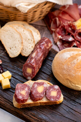chopping board of cheeses and salami cold cuts of various varieties homemade country bread with almonds and handmade knife