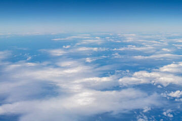 Fototapeta na wymiar White clouds against the blue of the Pacific Ocean seen from a plane near the Hawaiian Islands