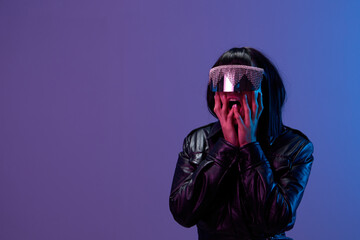 Shocked pretty awesome brunet woman in leather jacket trendy specular sunglasses open mouth touch cheeks posing isolated in blue violet color light background. Neon party Cyberpunk concept. Copy space