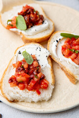 bruschetta with tomatoes and labneh cheese on a light background