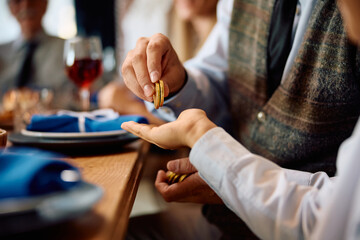 Close up of kid receiving Hanukkah gelt from his grandfather at home.