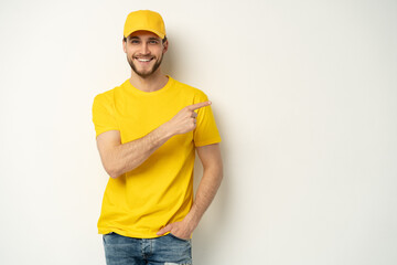Delivery man in yellow uniform isolated on white background. Professional smiling confident male employee in cap, t-shirt courier dealer