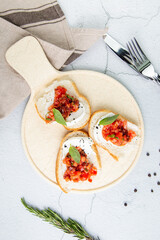 bruschetta with tomatoes and labneh cheese on a light background top view