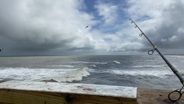 Fishing On Pier - POV Fishing Rod With Ocean Background