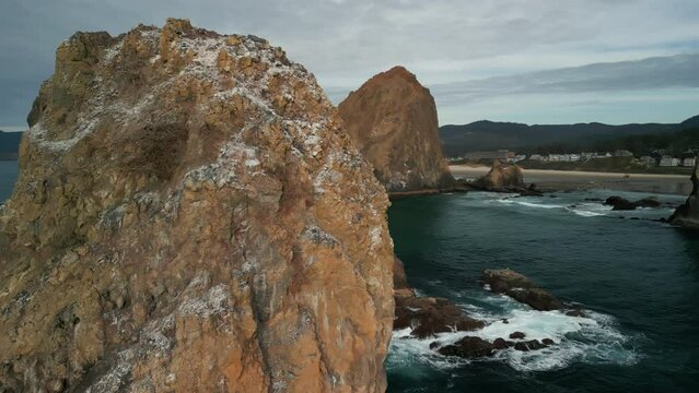Aerial shot of Haystack Rock beach in coastal town Cannon Beach, Oregon. Wide footage