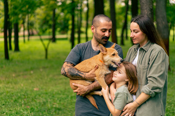 Obraz premium portrait of happy young family in park with dog dad mom daughter resting concept of trust care and family values