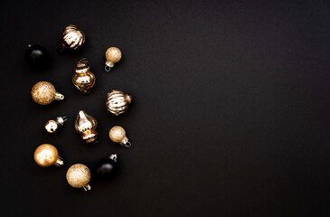 Flat lay of golden and black Christmas balls decorate on black background