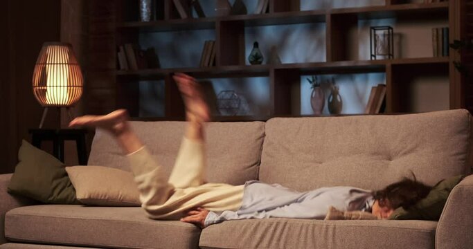 Woman collapses onto the sofa in the living room, her body sinking into the soft cushions. The weariness in eyes mirrors the challenges of the day, and movements lack their usual grace.