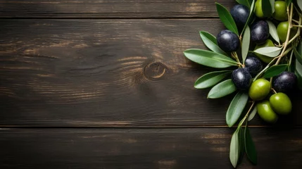 Gordijnen Green and black olives with leaves on a wooden background. © savvalinka