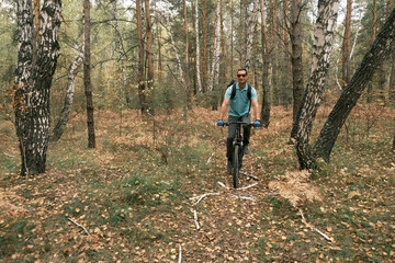Fototapeta premium active lifestyle.A cyclist with a backpack rides a mountain bike through the autumn forest.Mountain Bike