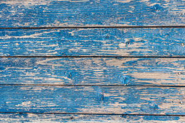 old wooden wall painted blue, weathered wooden background with nails and slits.