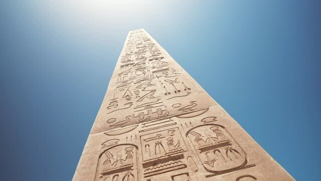 Replica of the tall Egyptian obelisk with hieroglyphs and clear blue sky in the background. The remains of ancient civilization