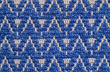 Knitted background. Blue white crochet texture with mosaic pattern.