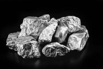piece of silver or platinum on the stone floor, on black background. Export ore from south africa