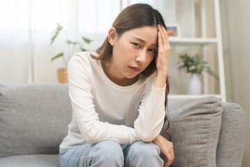 Dizzy asian young woman, girl headache or migraine pain suffering from vertigo while sitting on...