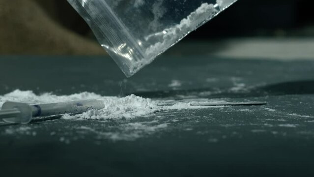 Drug addict preparing lines of heroin for injection 