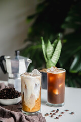Iced of latte coffee and ice blak coffee cup on glass cup on white table
