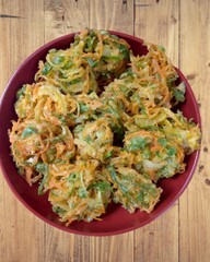Vegetable tempura and an oriental bowl on a wooden table, view from above.
