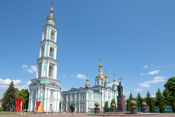 View of the Transfiguration Cathedral with the bell tower and the monument to Saint Bishop Pitirim on a sunny June day, Tambov