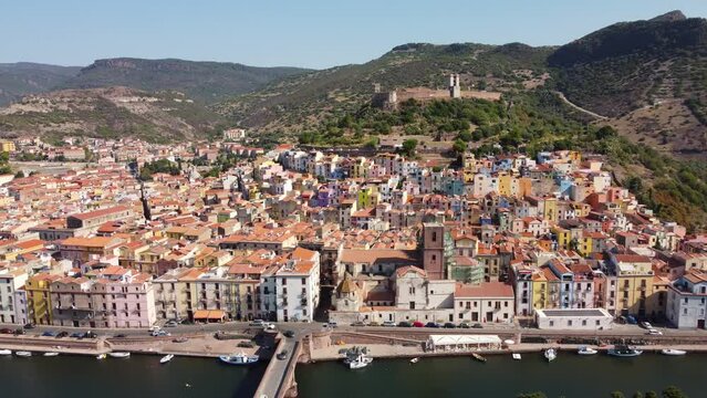 Aerial panning footage of Bosa, a small colourful town and the Temo river and Malaspina castle on the island of Sardinia in Italy