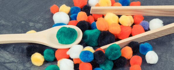 Colorful pompoms using for playing and development of kids motor skills, coordination and logical...