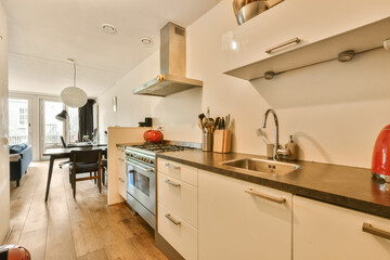 a kitchen and dining area in a house with wood floors, white cabinets and stainless steel appliances on the wall