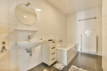 Fototapeta na wymiar a white bathroom with black tile flooring and wall mounted mirror above the sink in the room is very clean