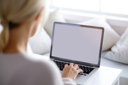 closeup female hand using white blank screen laptop online working in living room home working lifestyle