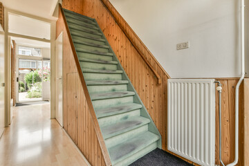 a staircase leading up to the second floor in a home with wood paneled walls and white trim on the...