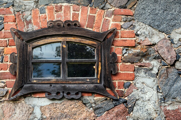 Wooden figured window in a brick frame on a stone wall. From the series Window of the World.