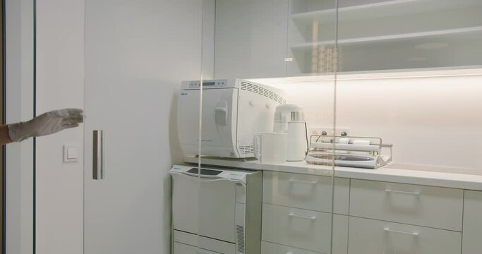 Manicurist assistant prepare and disinfect manicure tools at sterilization room with medical equipment at beauty salon. 