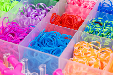 A set of multi-colored elastic bands for weaving bracelets for children.
