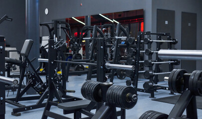 Fototapeta na wymiar Modern gym. Sports equipment in the gym. Barbells of different weights on a rack.