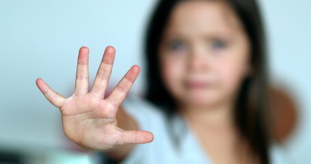 Little girl stop sign with hand, saying no, expressing defense or restriction
