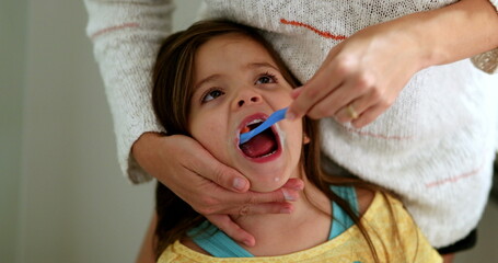 Parent brushing daughter teeth before bed. Mother brushes little girl tooth with toothbrush
