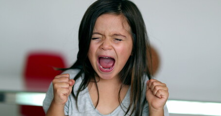 Upset little girl yelling feeling angry