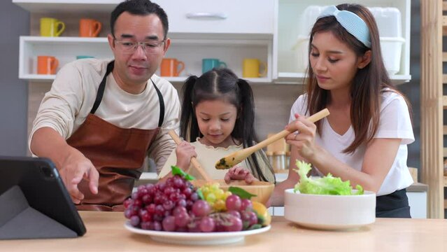 asian family enjoy cooking food or vegetables in kitchen