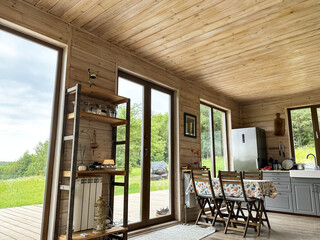 Cozy house interior, hygge home in rural place, countryside. Wooden furniture, panoramic windows