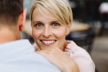 Portrait of beautiful couple in restaurant, on romantic date. Wife and husband touching foreheads,...