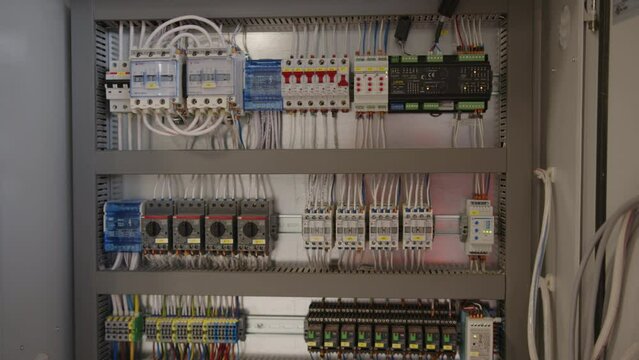 Electrical control cabinet of an industrial wood drying complex with circuit breakers, wiring and electronic control equipment for timber processing.


