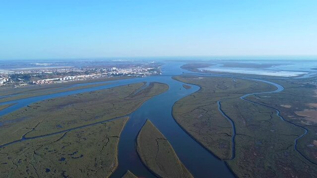 Aerial view of the river Odiel mouth. Estuary of Rio Odiel in the marshes named "Marismas del Burro" of Huelva with Huelva city in the background