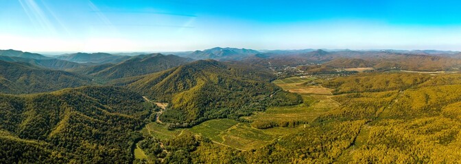 the valley of the Shapsukho River near the village of Defanovka and the Black Sea on the horizon (Western Caucasus, South Russia) on a sunny day in early autumn - aerial panorama