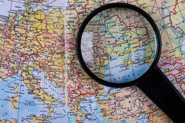 Detailed world map from black magnifying glass over Ukraine. Europe, travel destination concept. Map under the magnifying glass. Close up