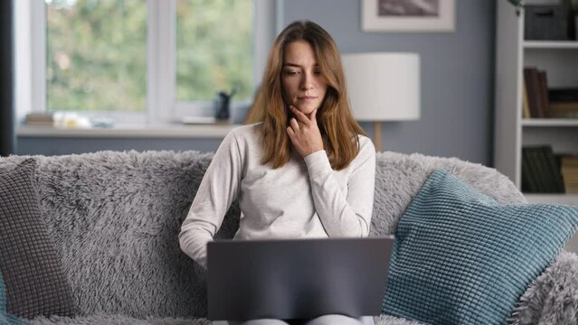 Successful and creative female businesswoman efficiently manages her e-business tasks with email correspondence, thinking and look at window