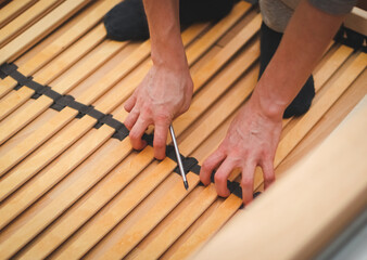 The hands of a caucasian young man are leveling in the middle a black textile fastening