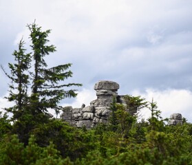 Obraz premium A rocks formation in Karkonosze National Park, sms’en from faraway through a pine forest