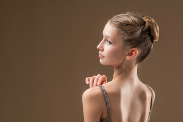 Portrait of a beautiful young girl professional ballerina student with pointe shoes in a leotard on...